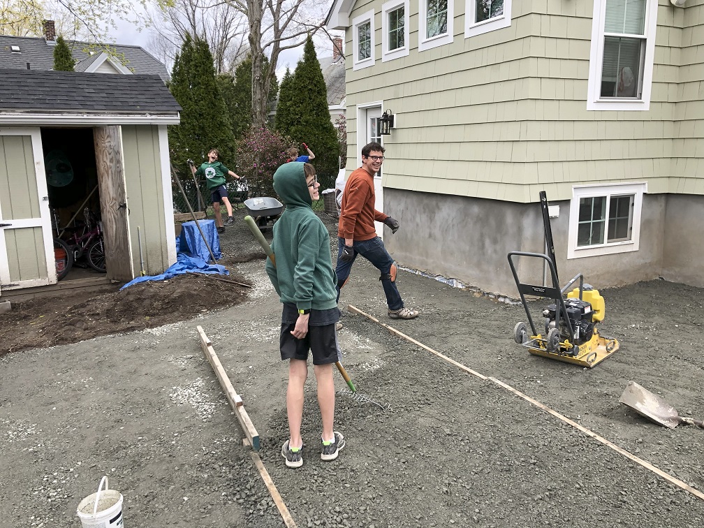 Henry working on the patio with kids helping